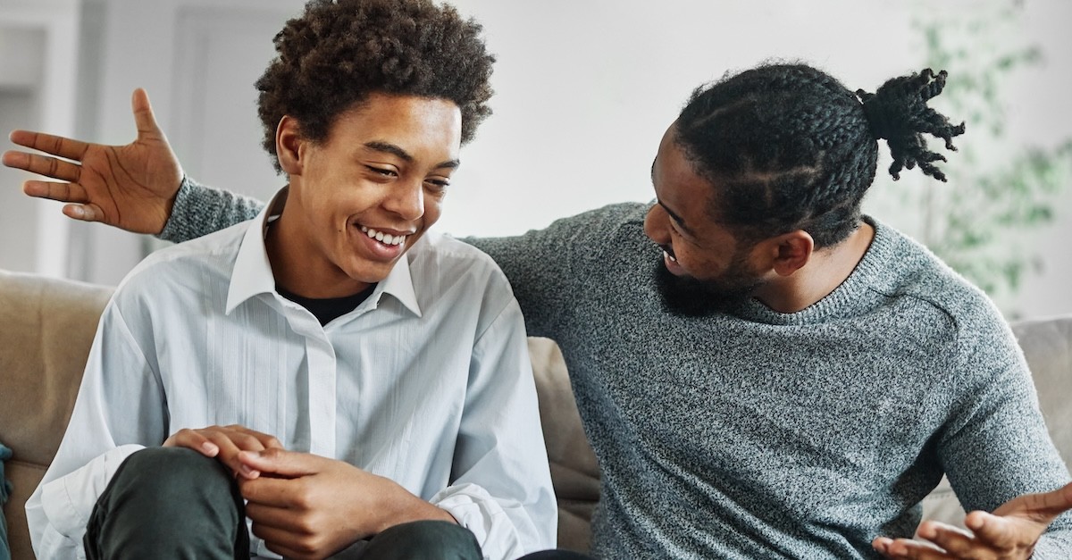 dad and teen son chatting and smiling