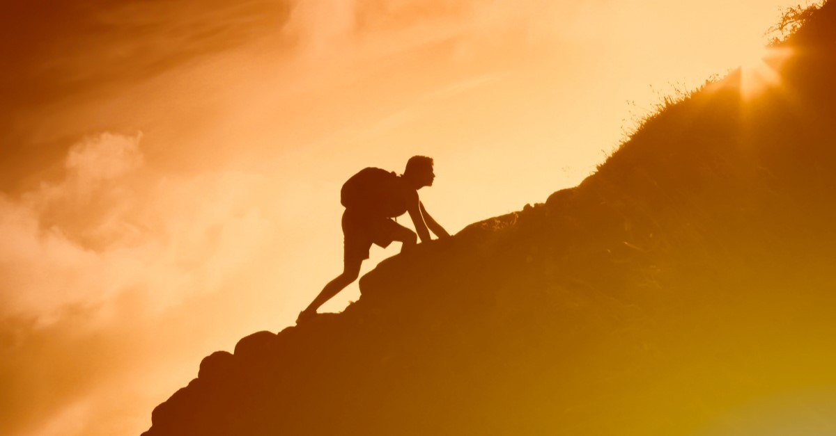 image of man climbing mountain to represent perseverance