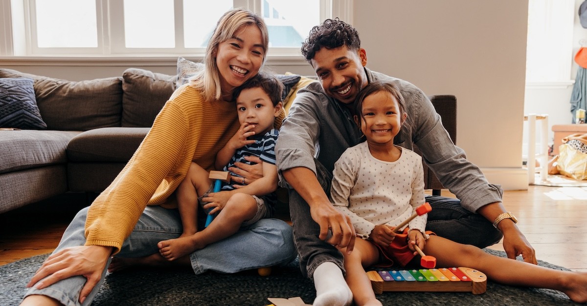 Happy parents mom and dad playing with two kids family