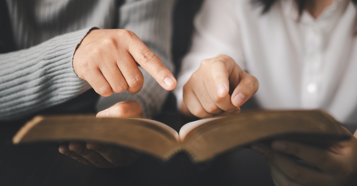 Parent and teen reading Bible study together