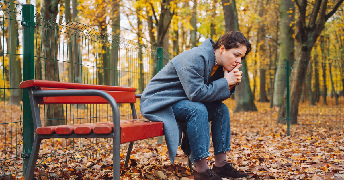 woman sitting alone autumn leaves reflection
