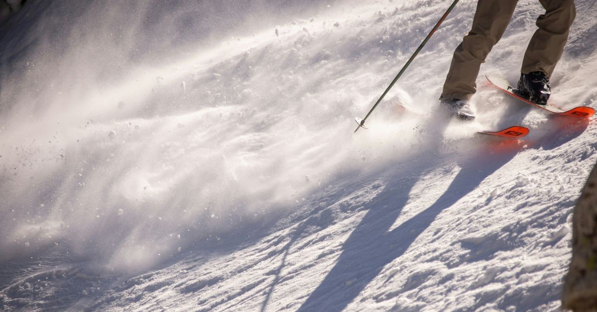 Downhill Snow Skier Skiing Down a Mountain - Photo of Skiis and Spraying Snow