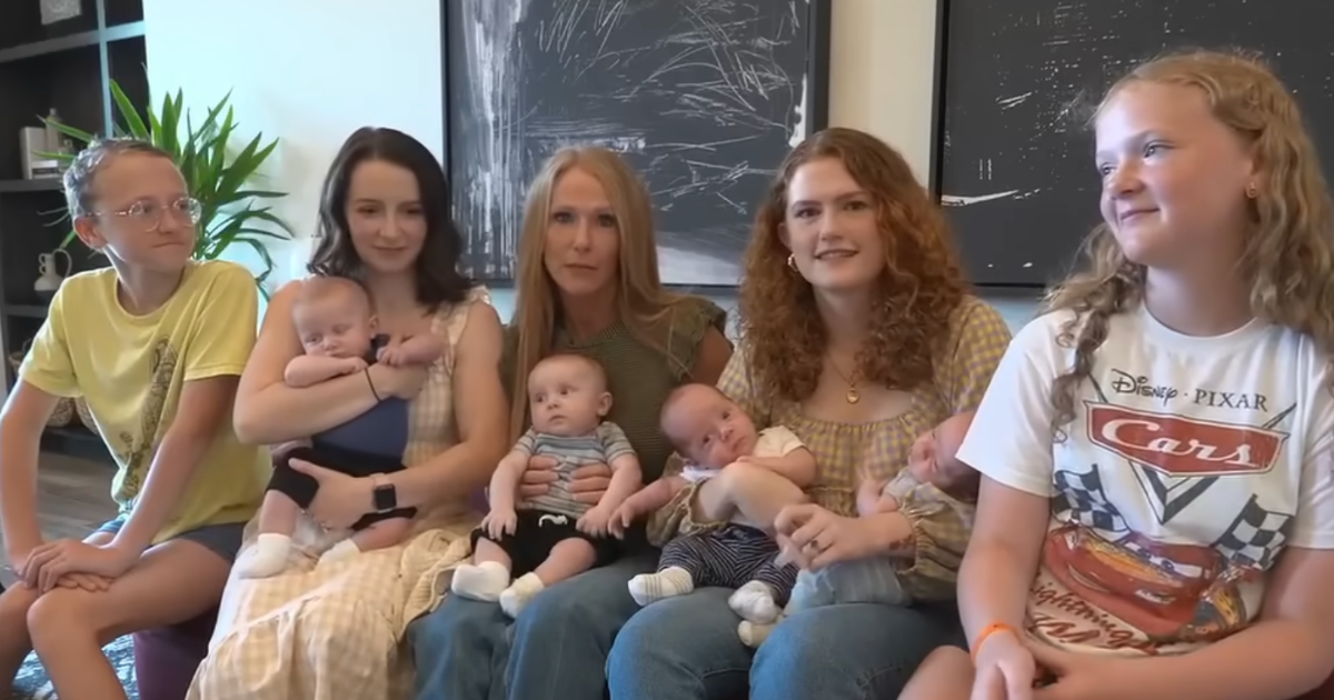 sisters holding 2 sets of newborn twins