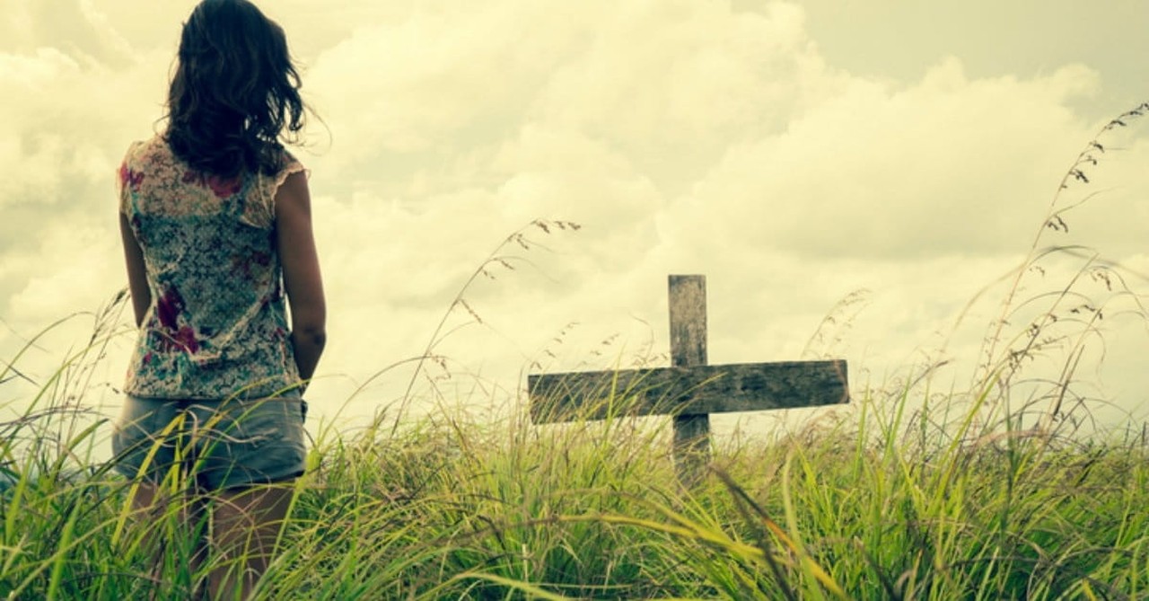 girl looking at a cross