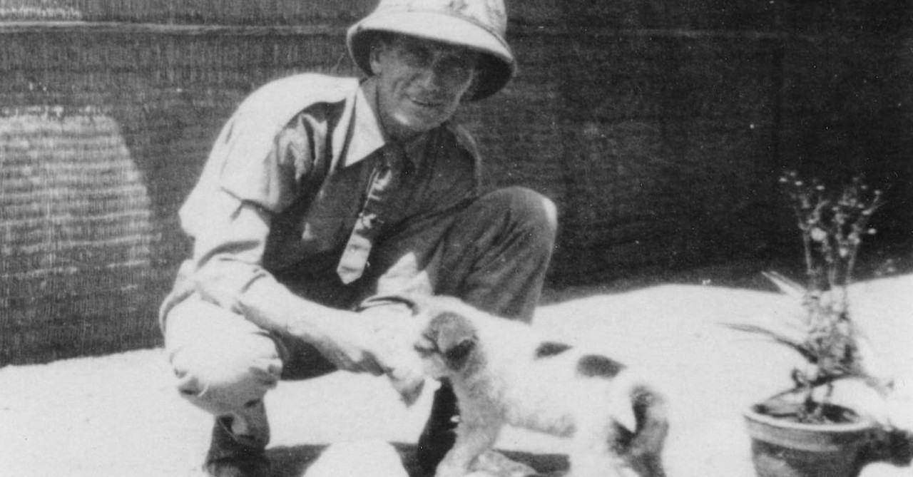 Oswald Chambers in pith helmet petting a dog