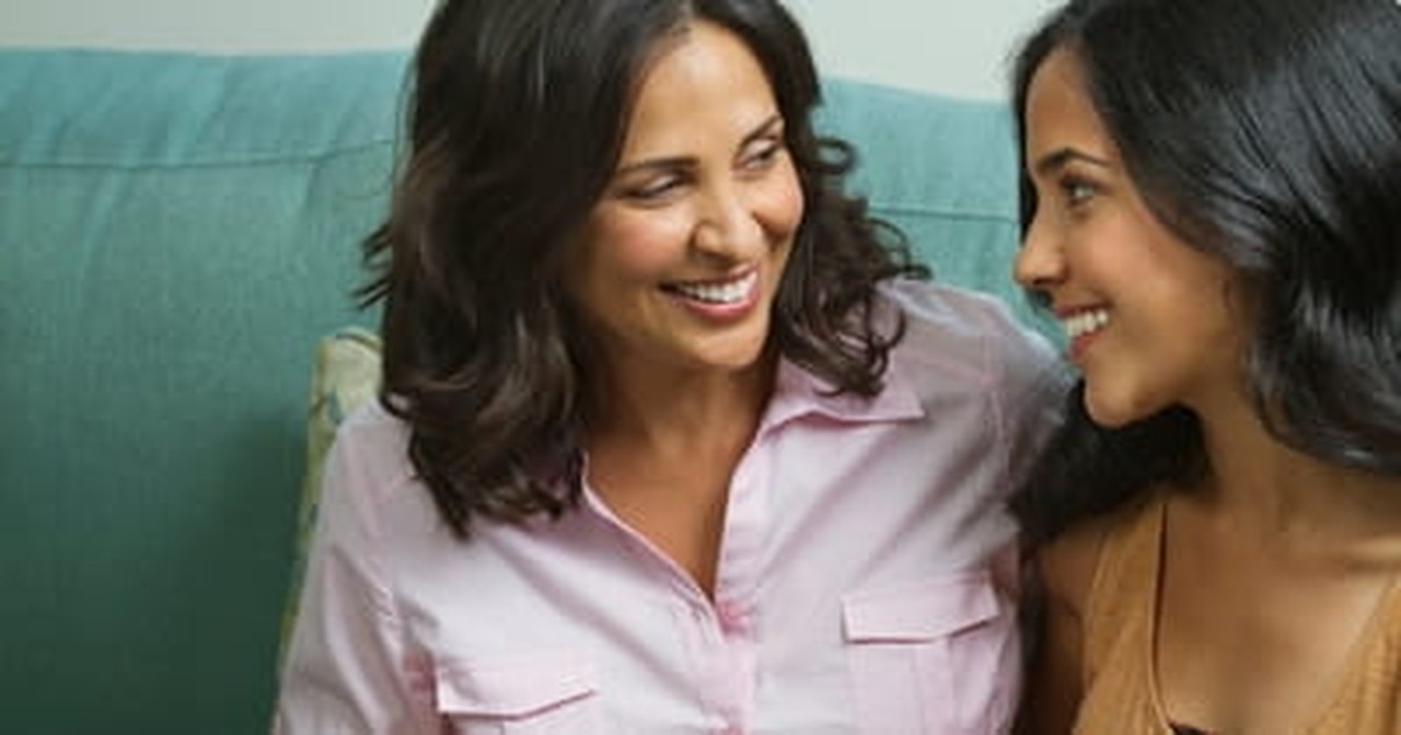 mother and daughter sitting together talking smiling