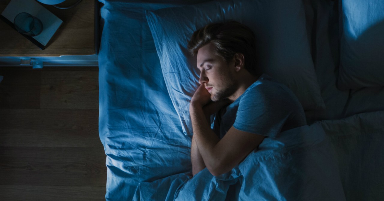 man sleeping peacefully in dark room