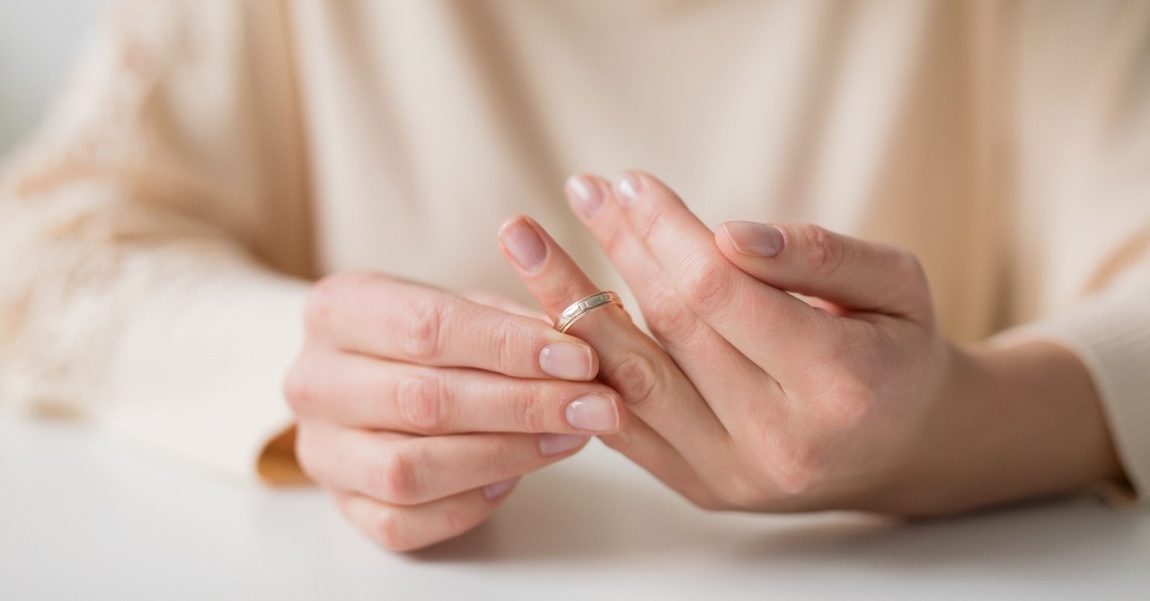 woman taking wedding ring off finger