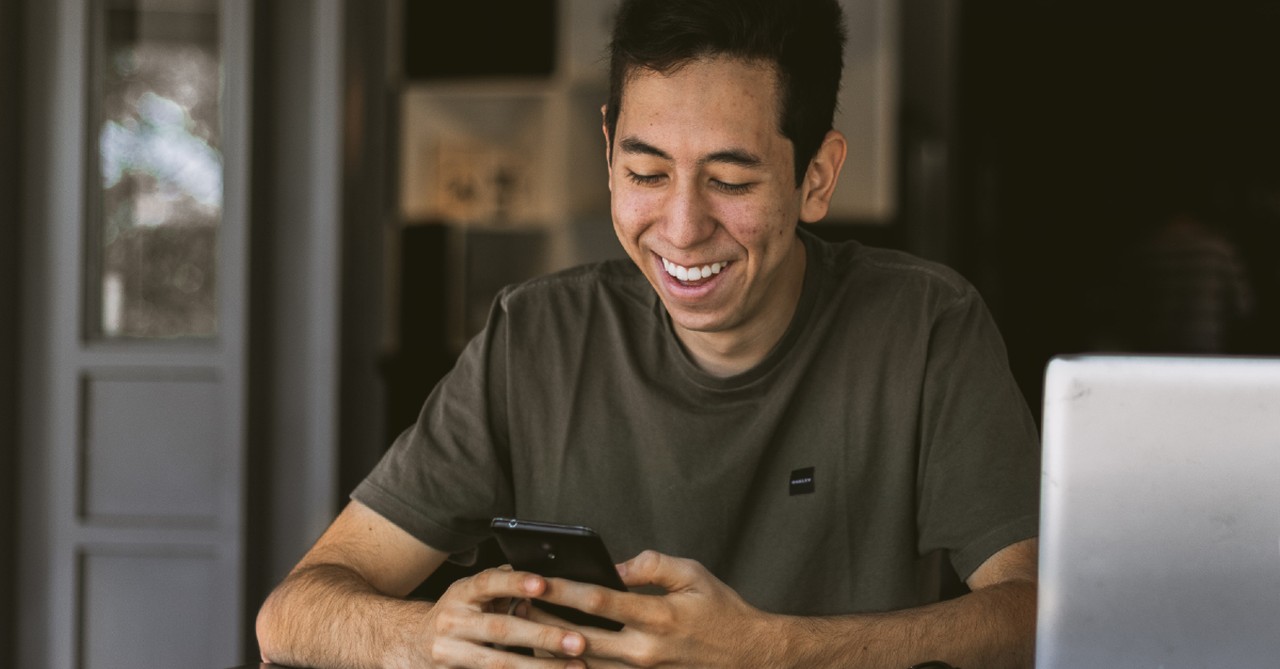 man getting text and smiling