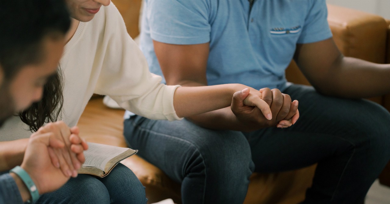 adults holding hands in prayer bible study