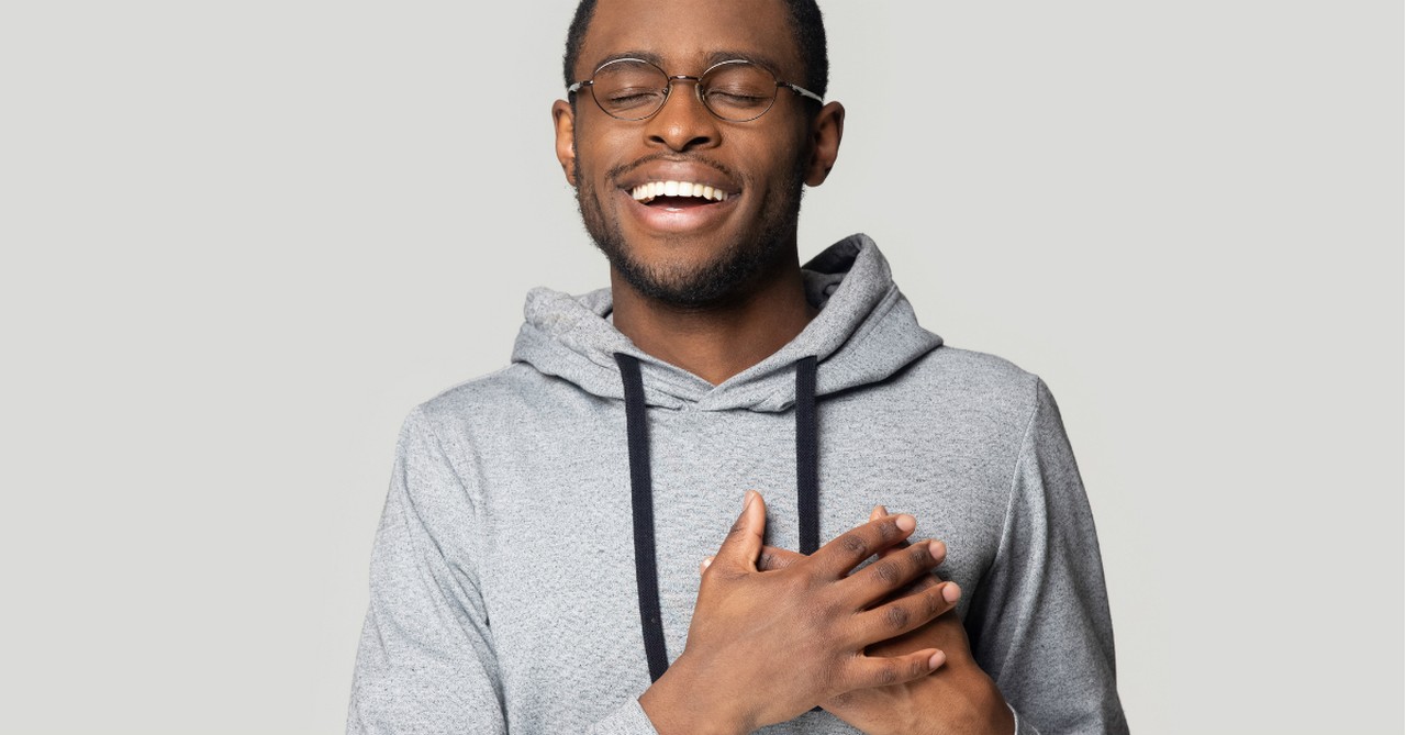 man smiling hands over heart, differences between giving up and letting go