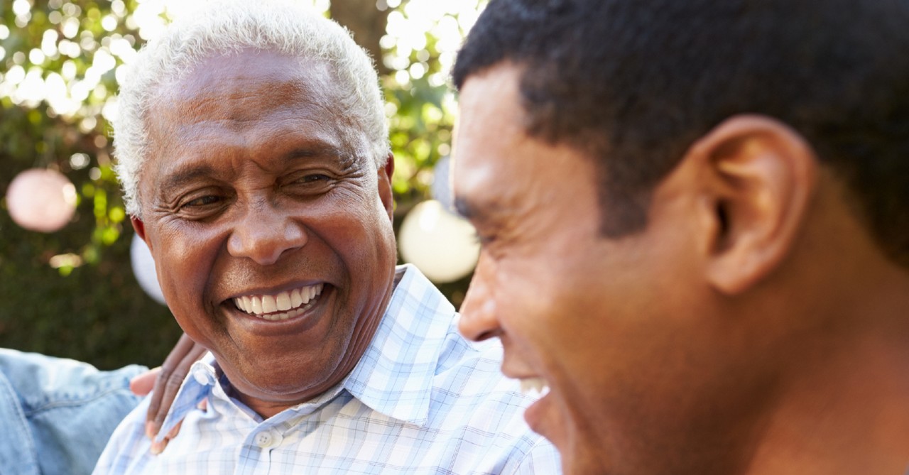 senior father with adult son laughing