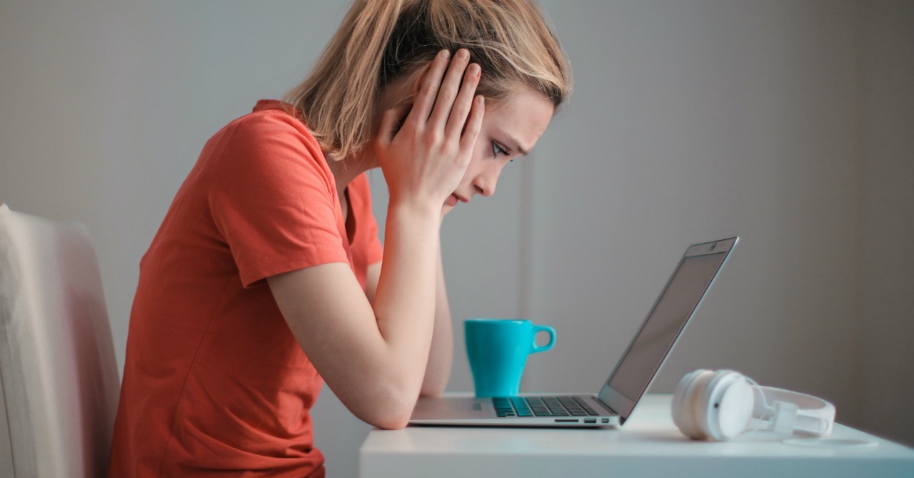 young troubled woman using laptop at home