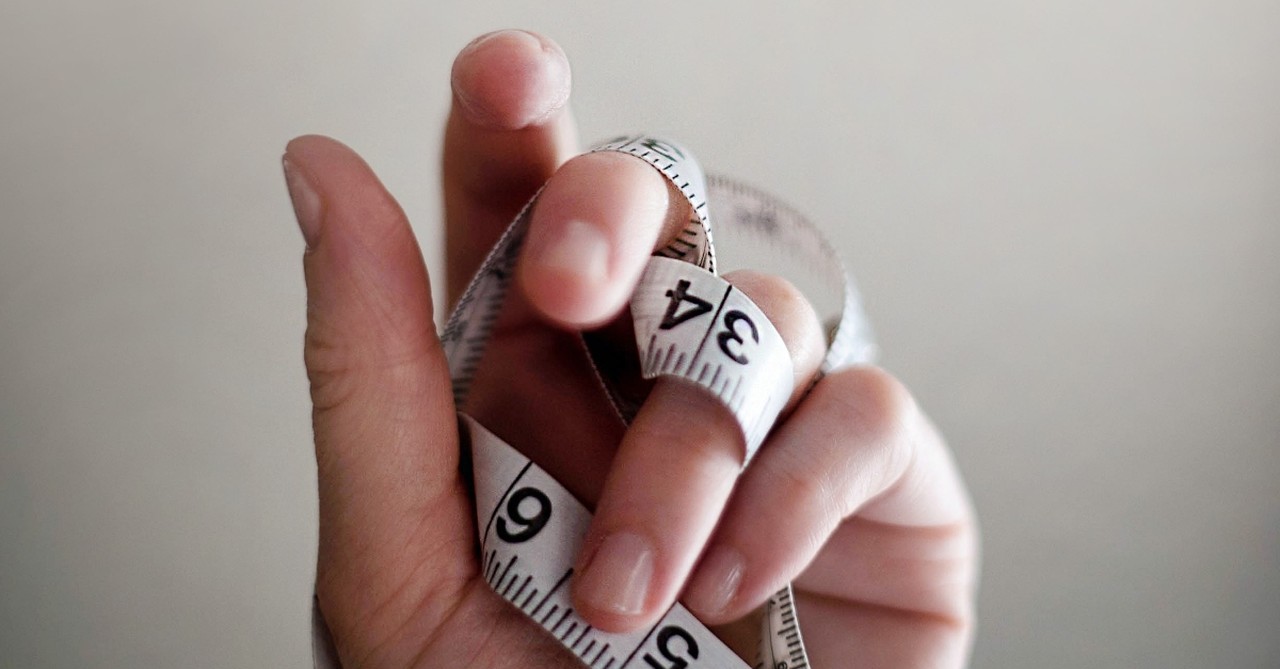 close-up of hand holding measuring tape