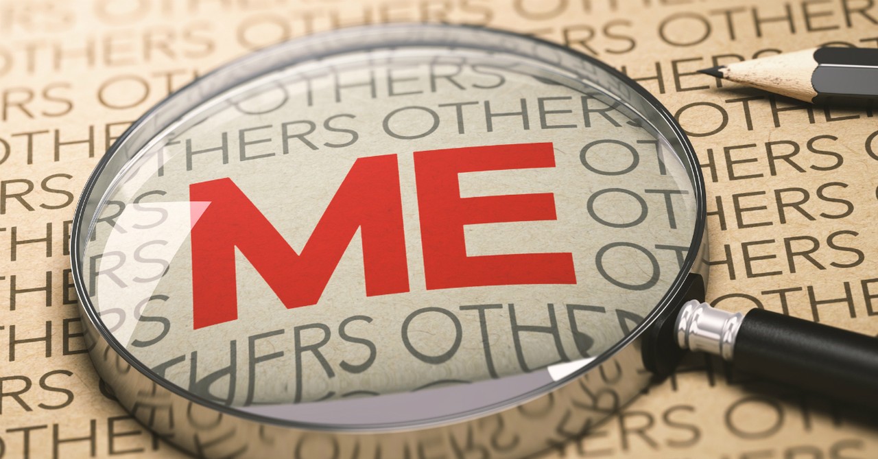 magnifying glass laying over the word me self-centered, warning signs of a narcissistic pastor