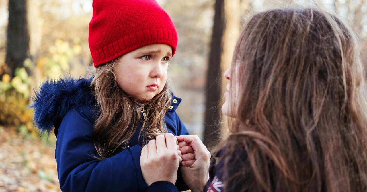 mom talking to toddler that is crying