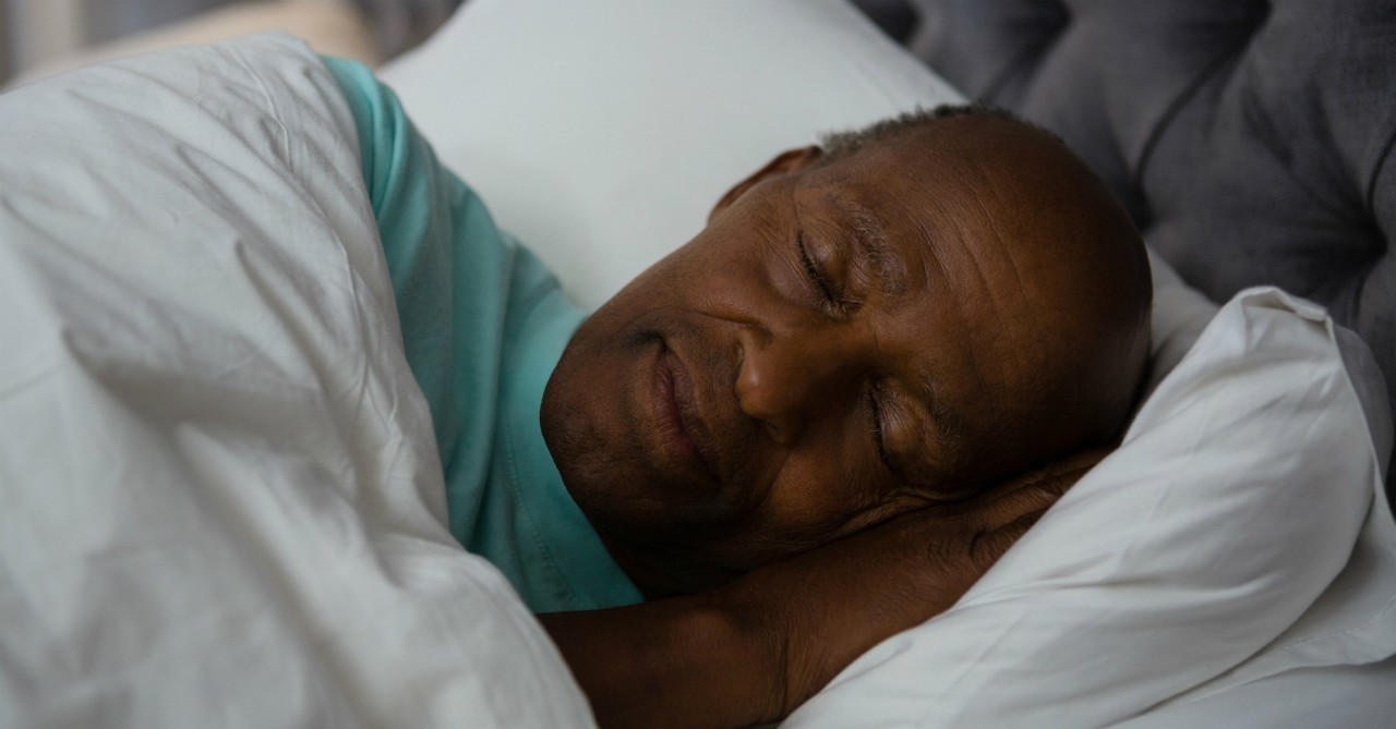 man sleeping on pillow in bed