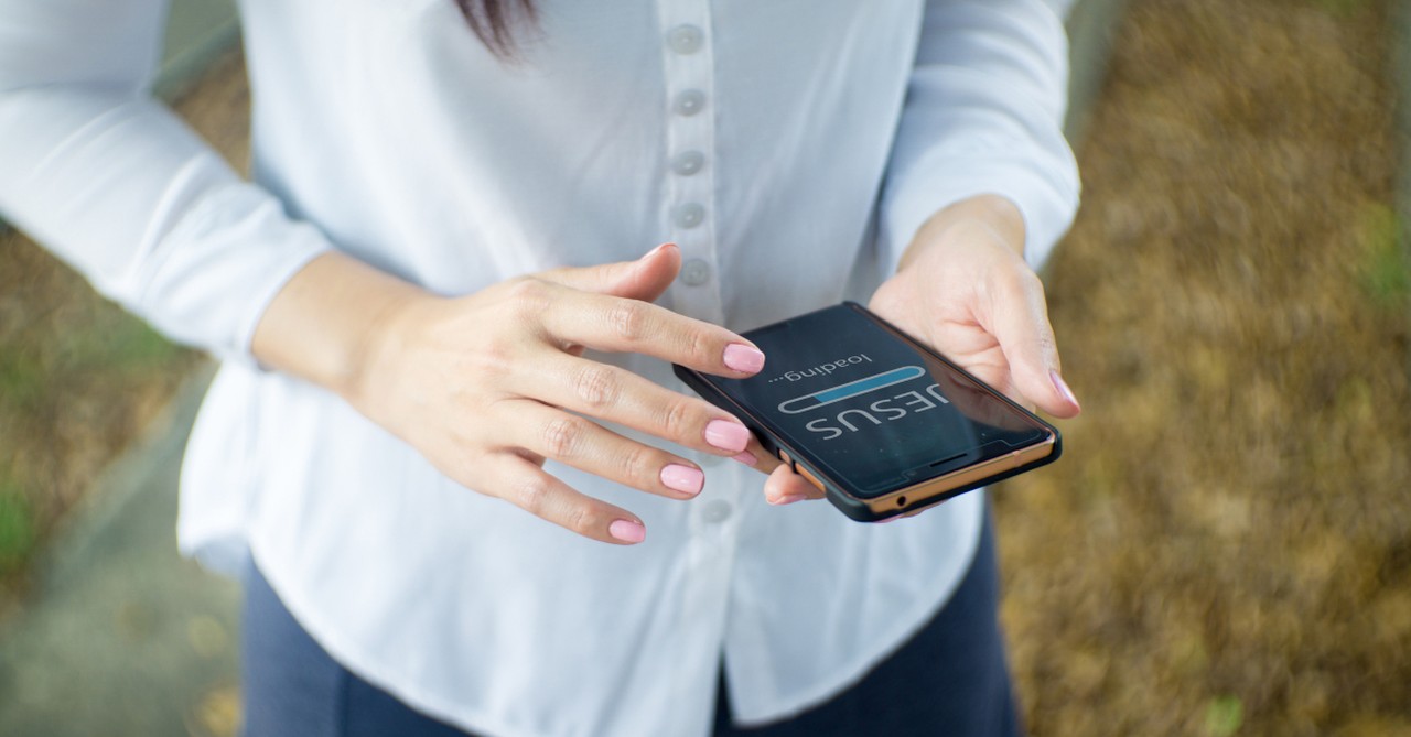 woman on cell phone downloading Jesus