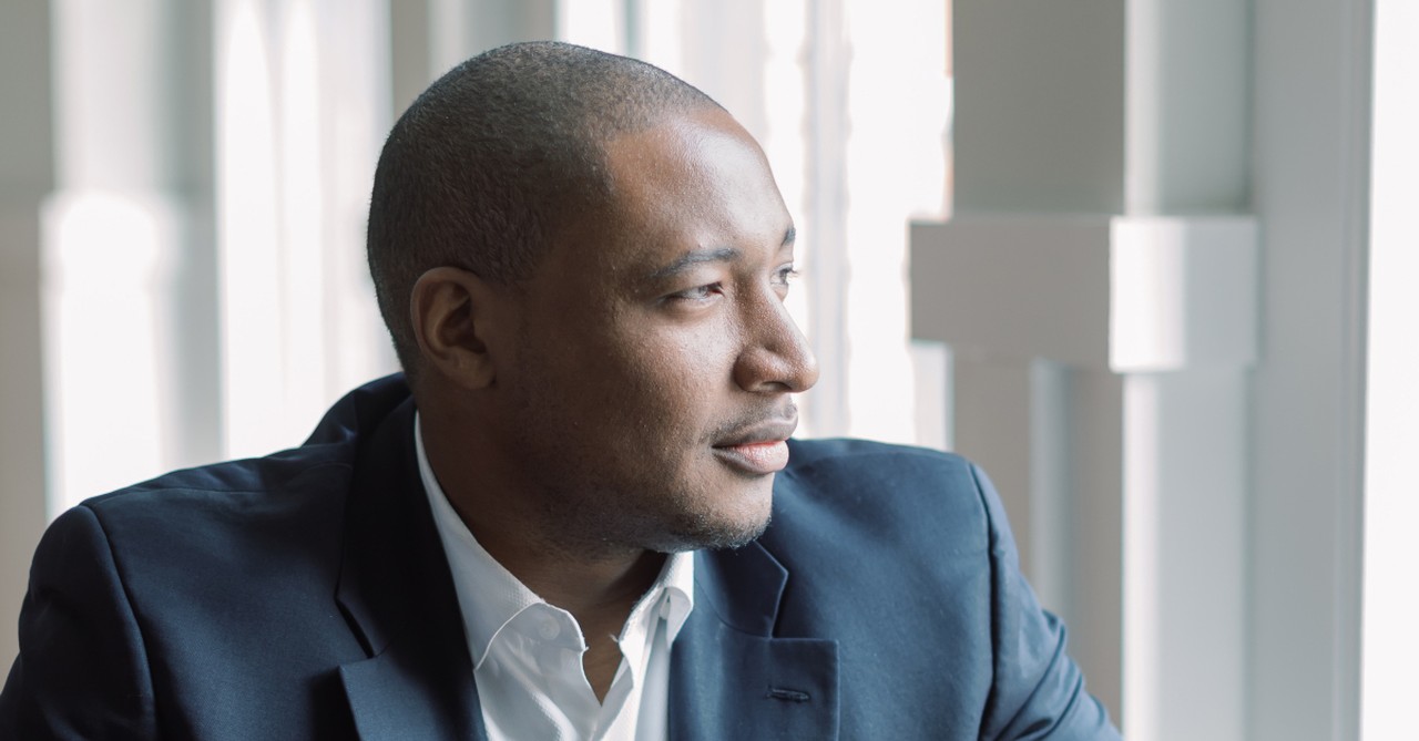 man in suit deep in thought looking out window pastor