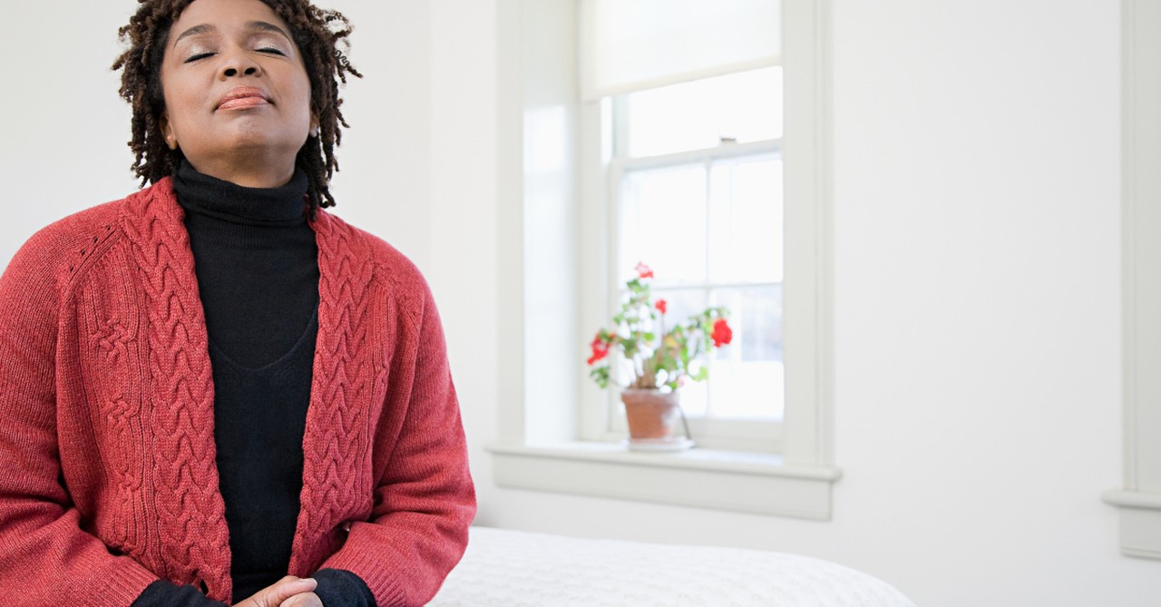 woman looking up eyes closed in prayer