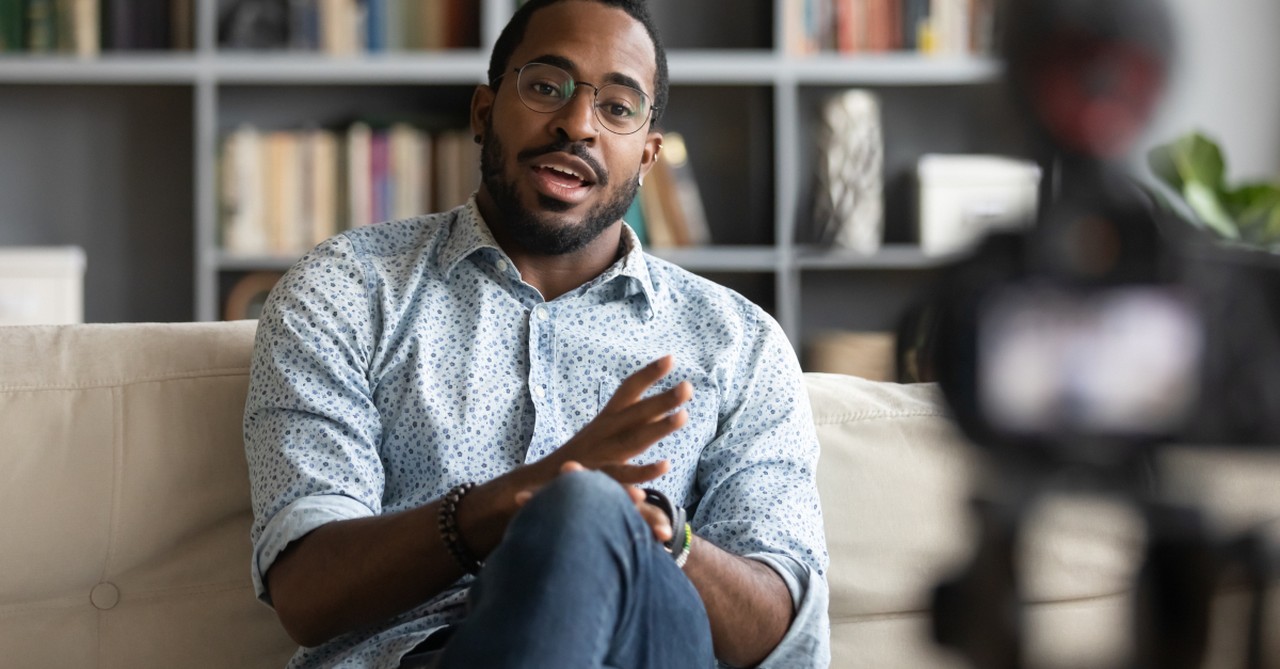 man speaking into video camera for online church