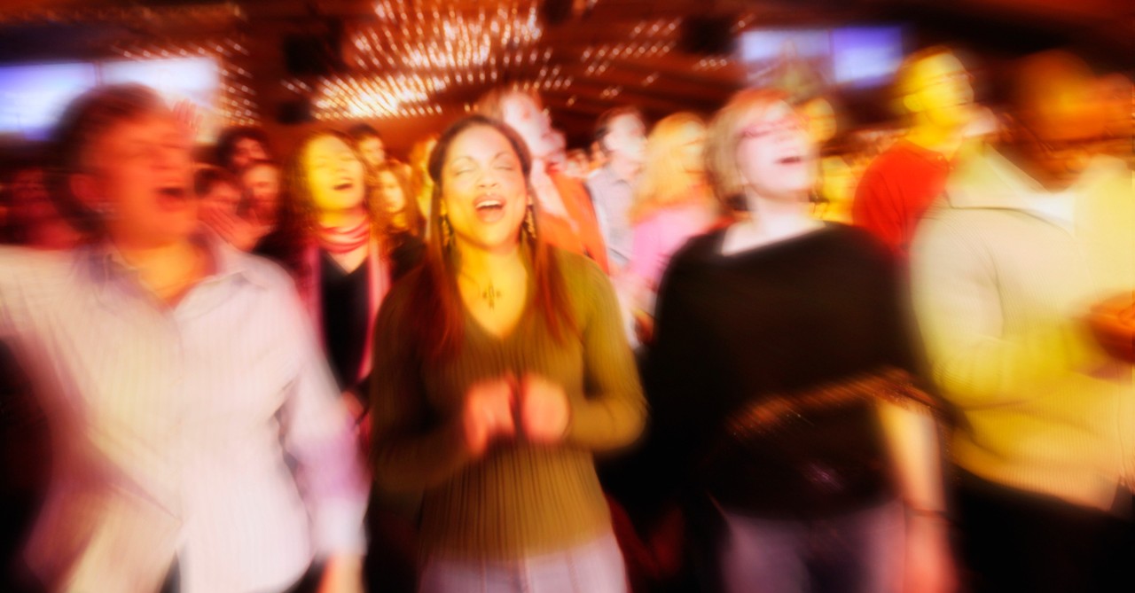 blurry group of adults worship singing