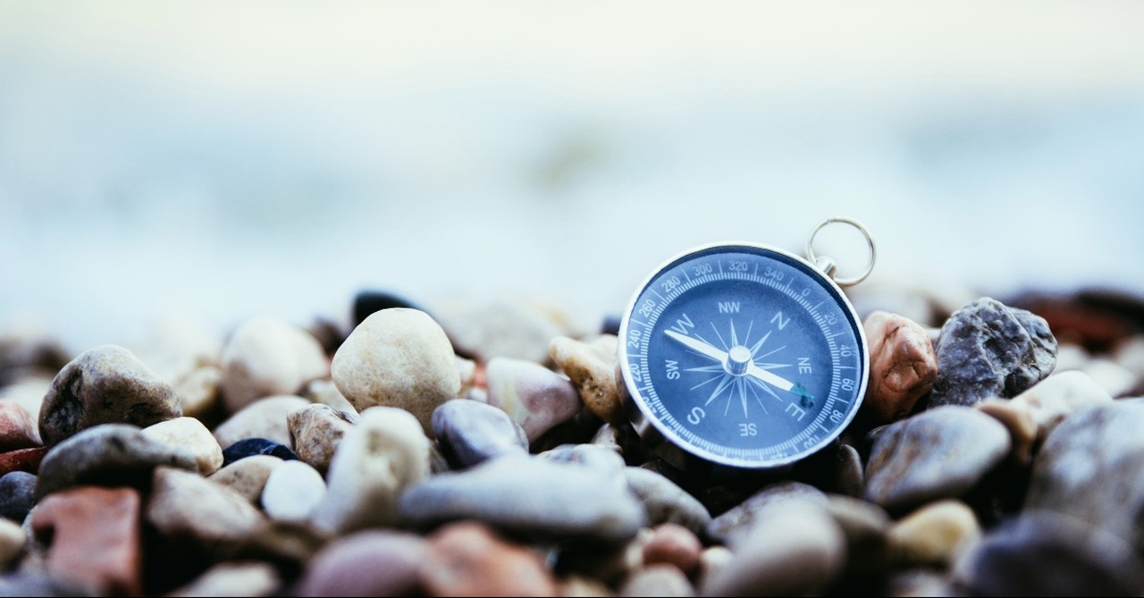 Compass on a stony beach, god shows up in our darkest hours