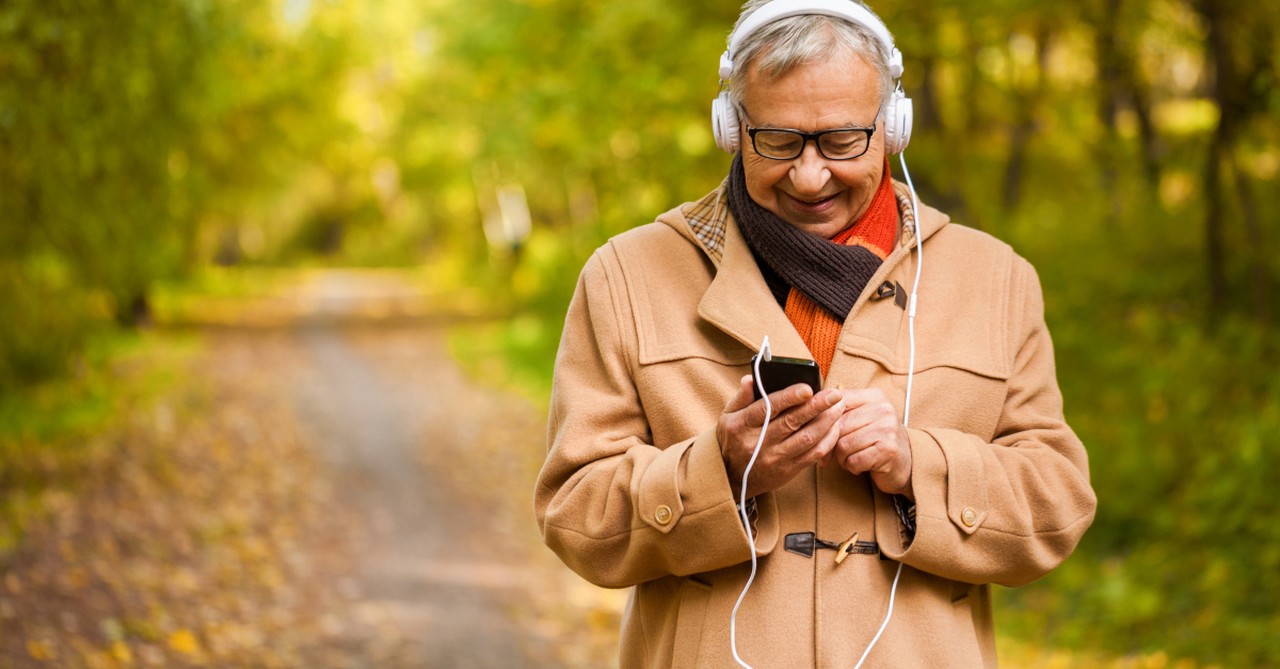 senior walking listening to bible on headphones