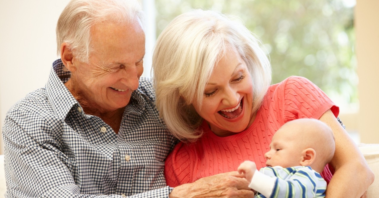 Older couple holding a baby boy