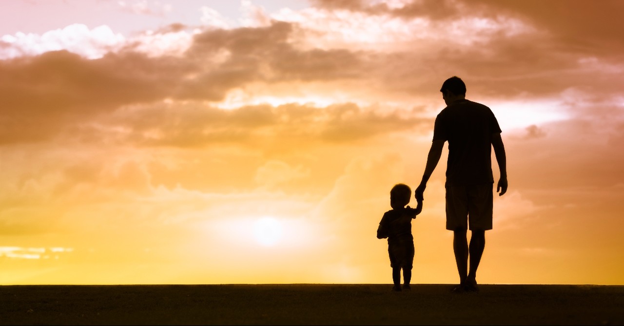 Silhouette of a father with his young son