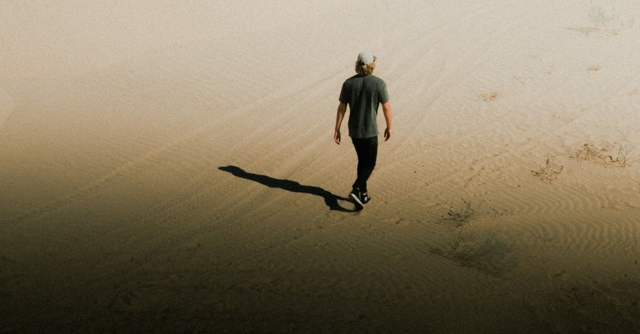 young man walking through desert alone, prodigal child