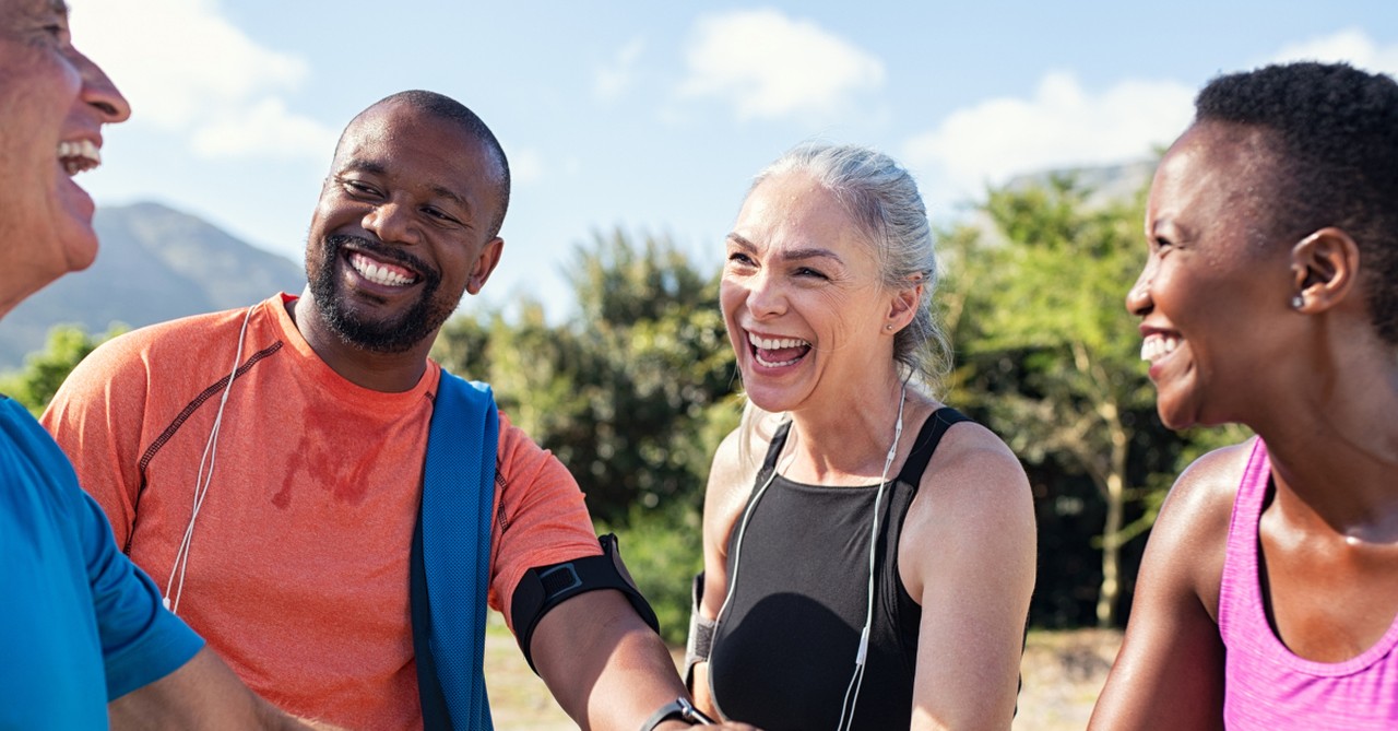 two active senior couples laughing outdoors