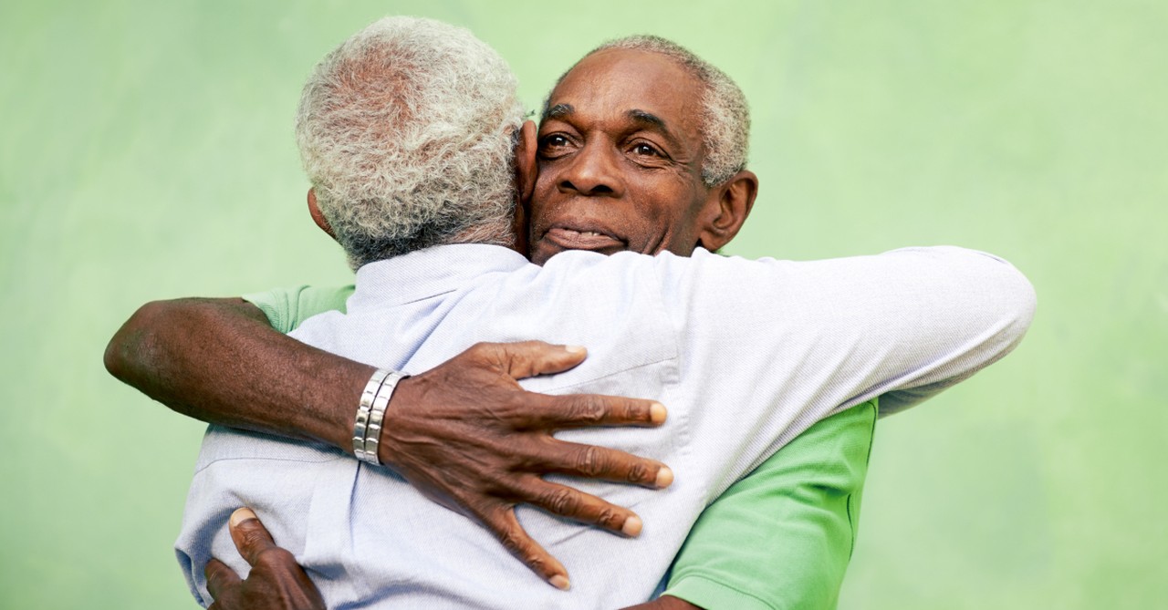 senior man hugging other senior man mentor