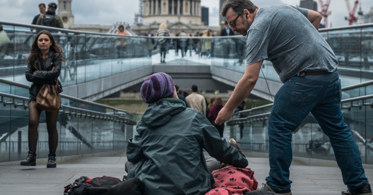 man giving to homeless beggar on street