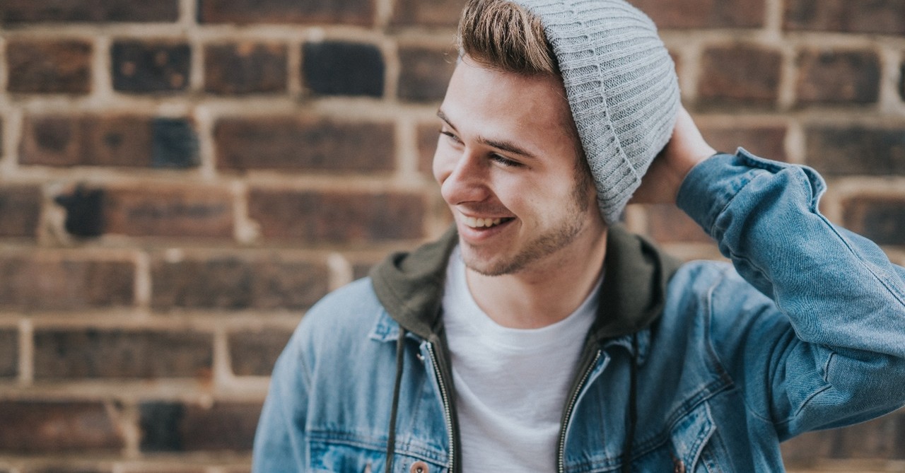 young man looking happy in street clothes and beanie, we need to teach sons modesty too