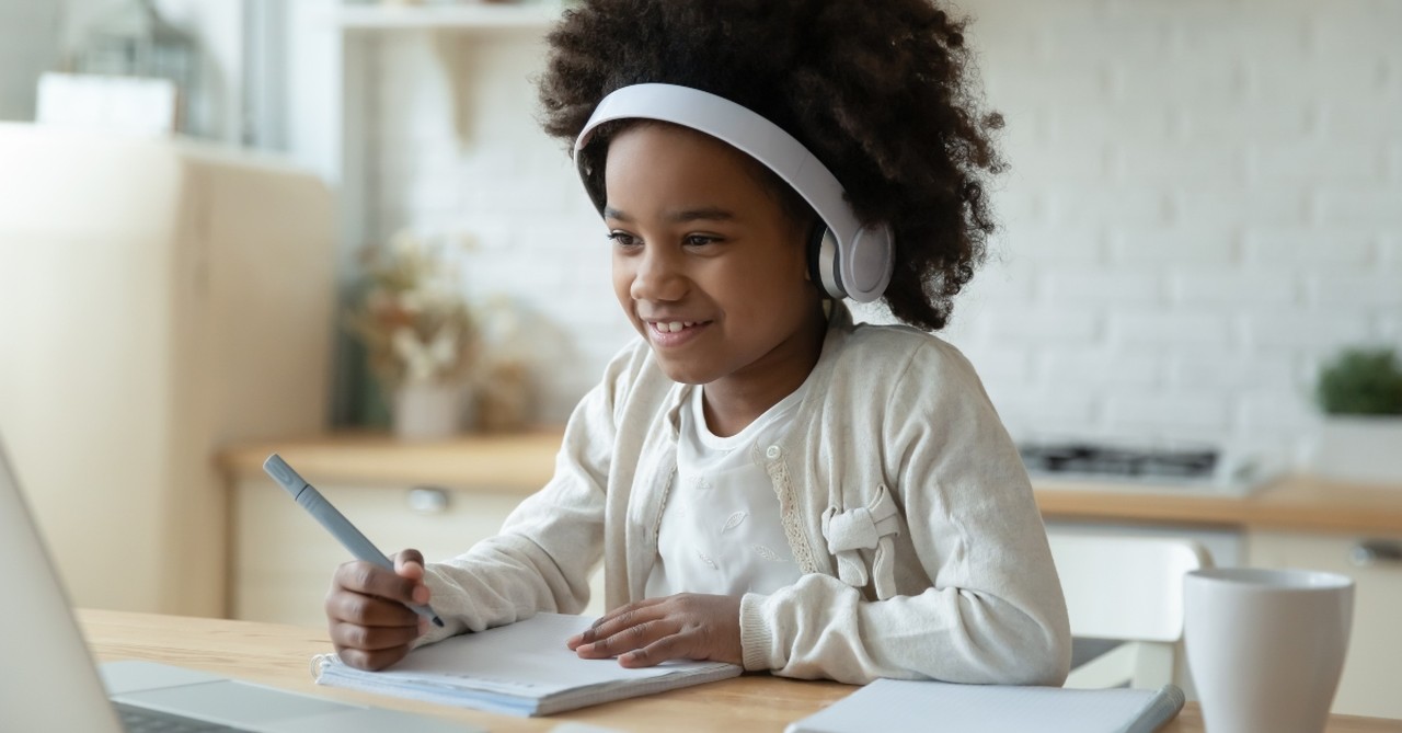 Young girl doing schoolwork on a laptop