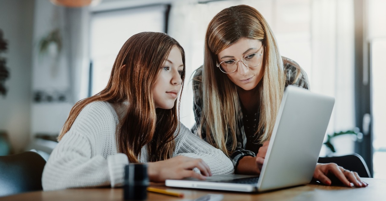 Mom and daughter working on schoolwork together