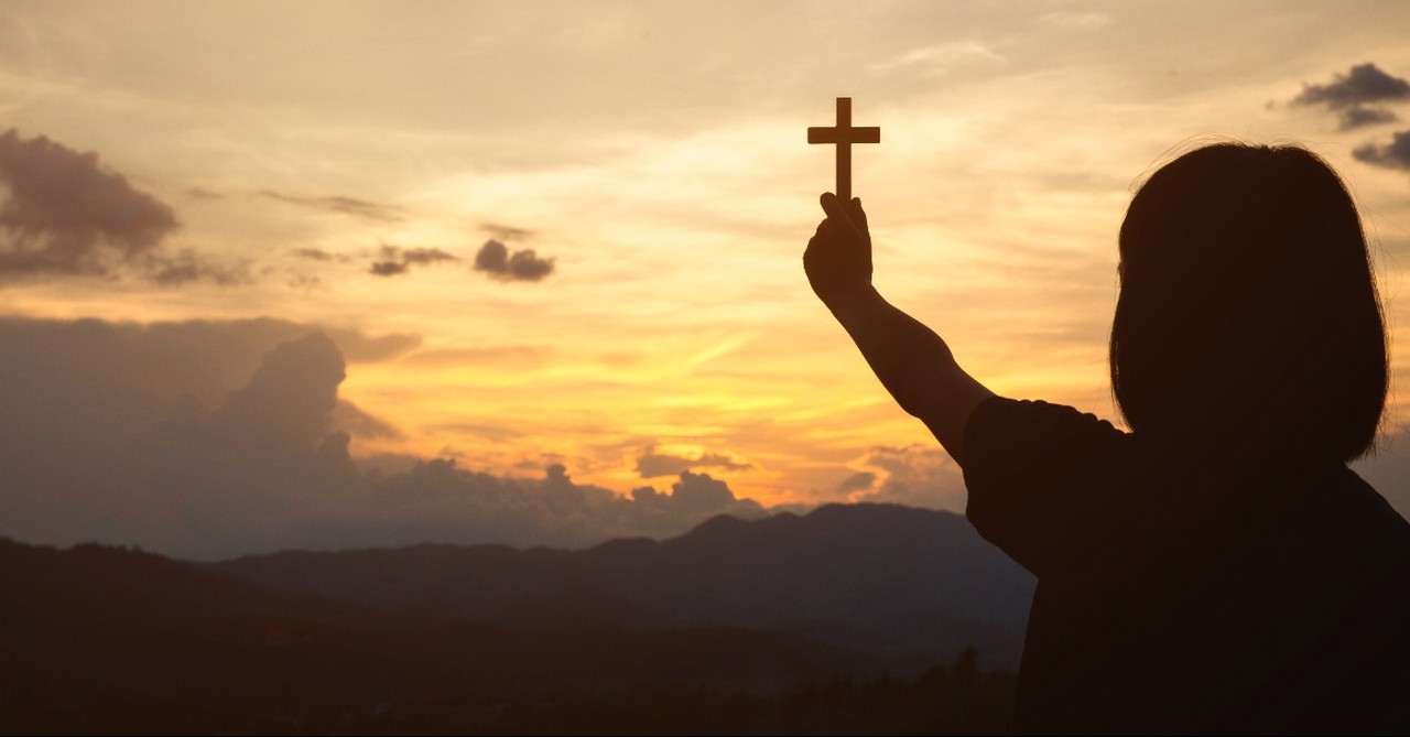 Girl holding up the cross