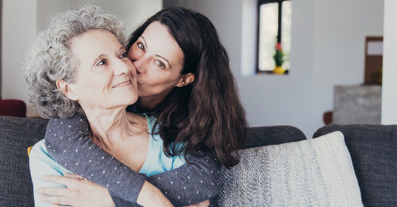 adult child with senior mom hugging