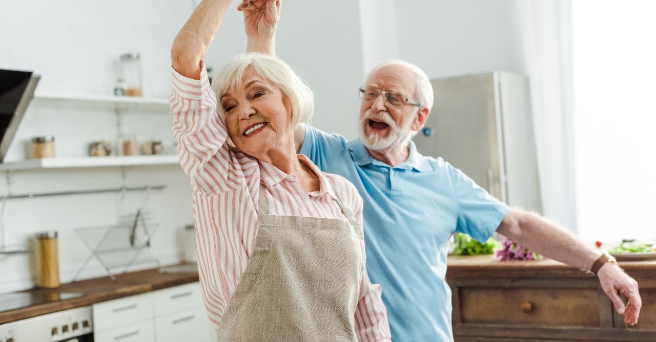 happy senior couple dancing in the kitchen, wonderful time to be alive