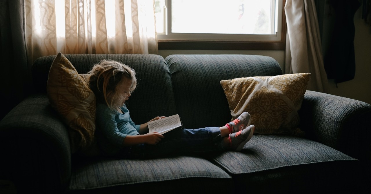 girl on couch reading, thankfulness journaling for kids