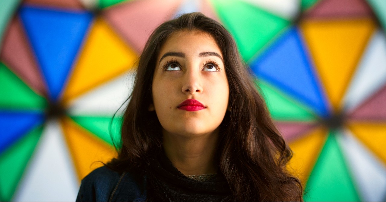 Woman looking up with a stained glass window behind her