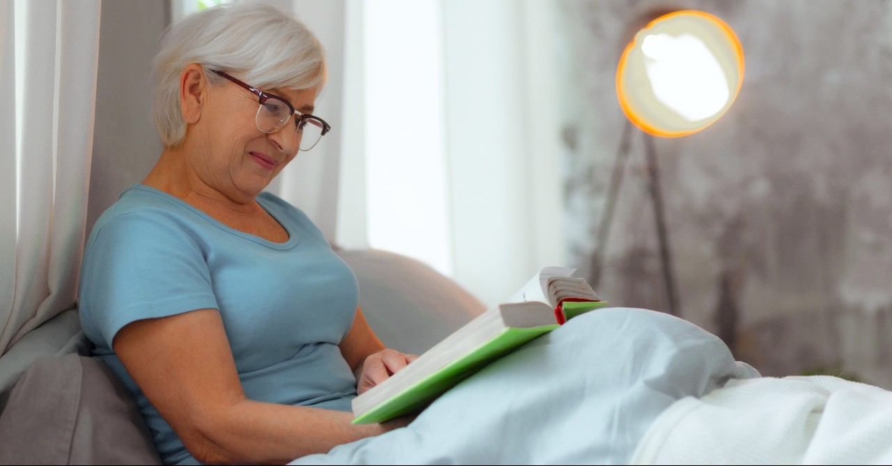 Elderly woman reading the Bible in bed