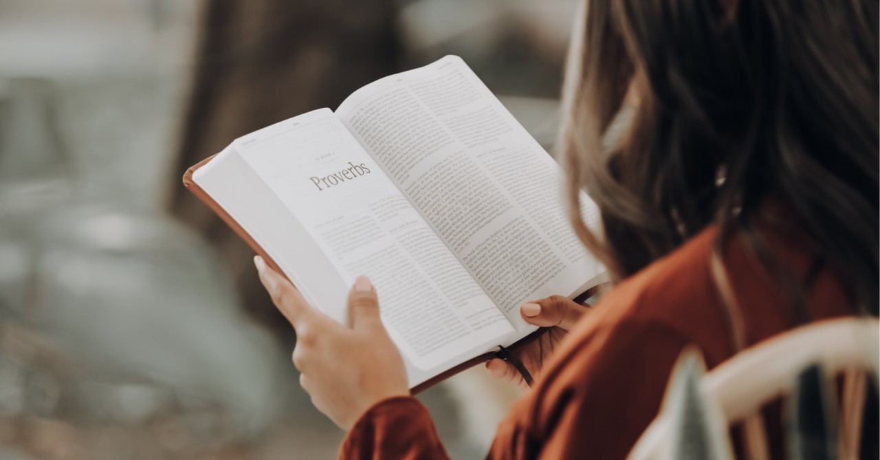 A woman reading a Bible, the Bible is translated into its 700th translation