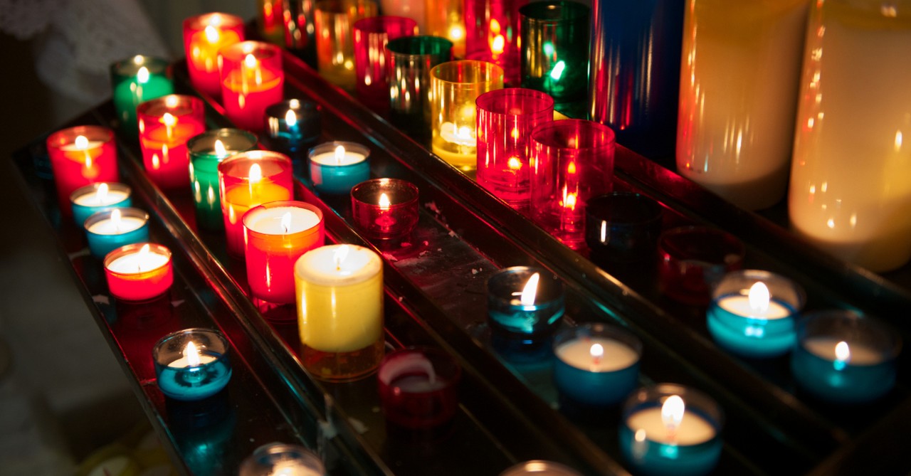 many candles lit in church to represent All Souls Day