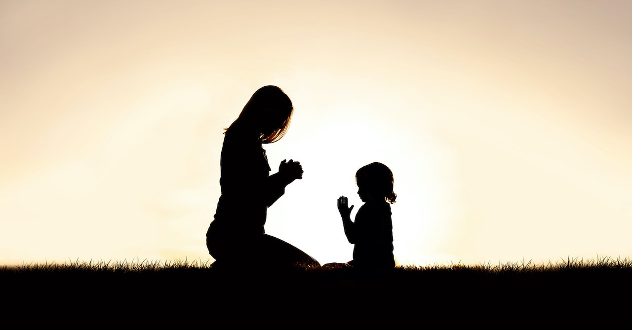 silhouette at sunset of mother and daughter praying outside, lessons on prayer mary and elizabeth