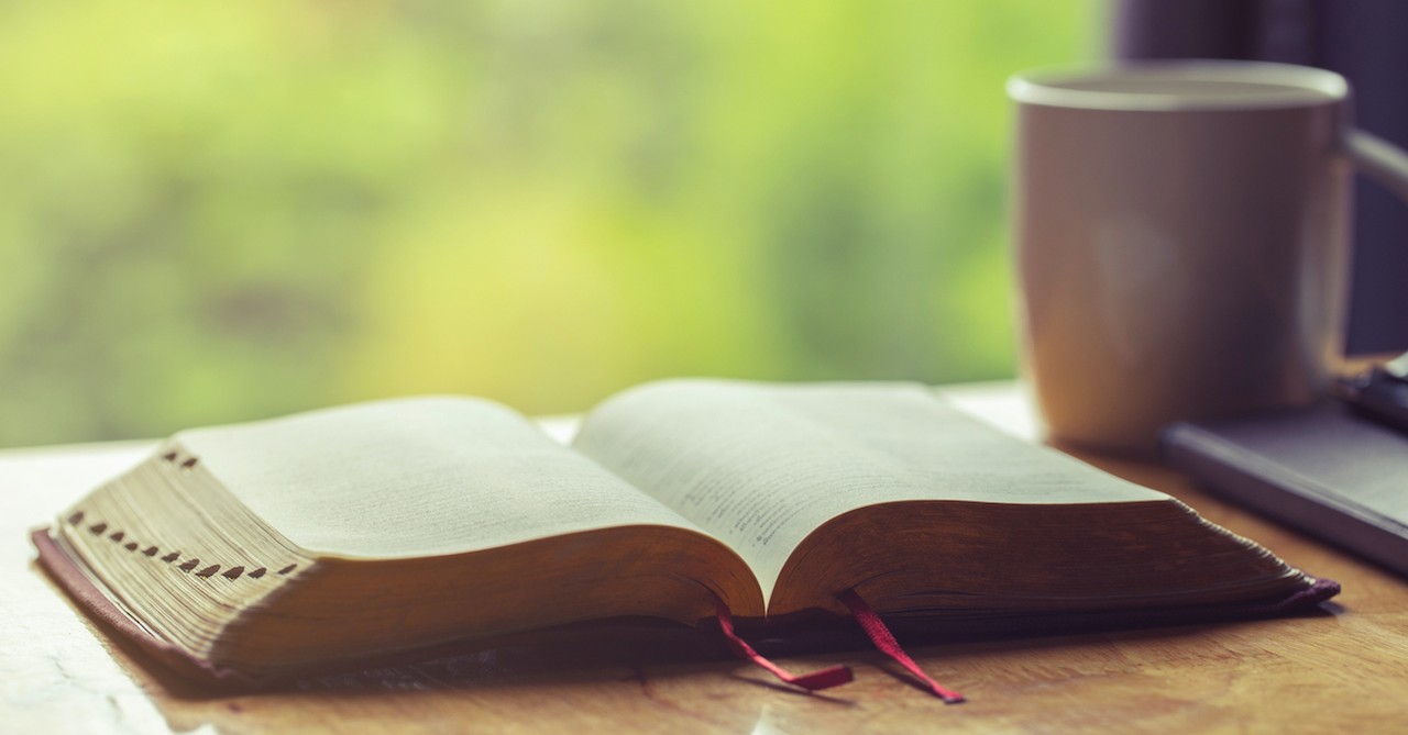 open Bible to psalms on table with coffee mug