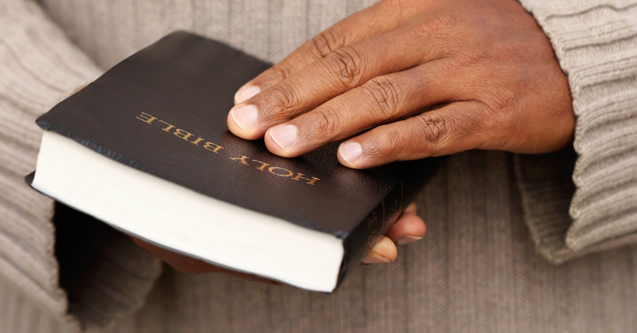 man hands holding open bible