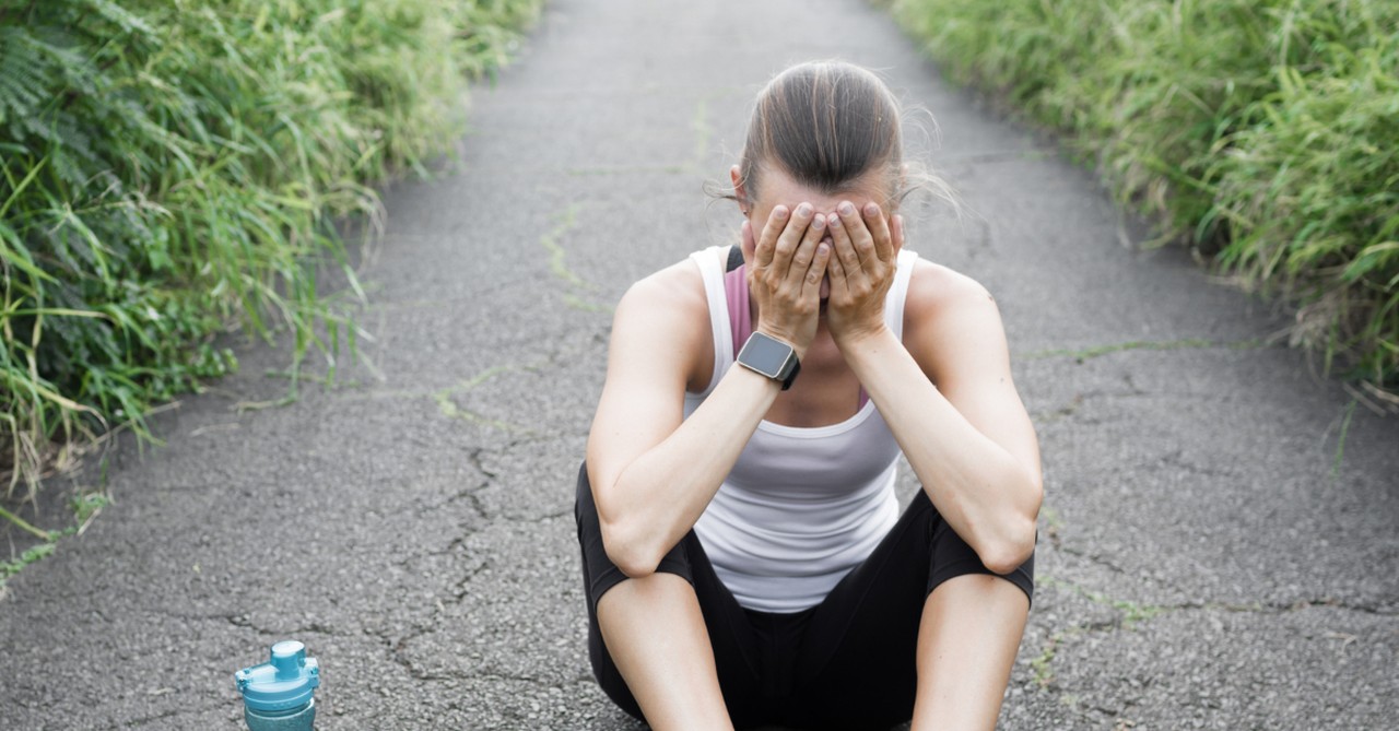 woman exhausted after running holding face in hands