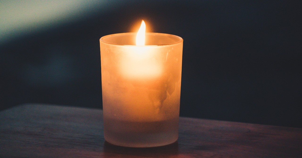 lone candle light in dark setting, hymns for trusting God in grief